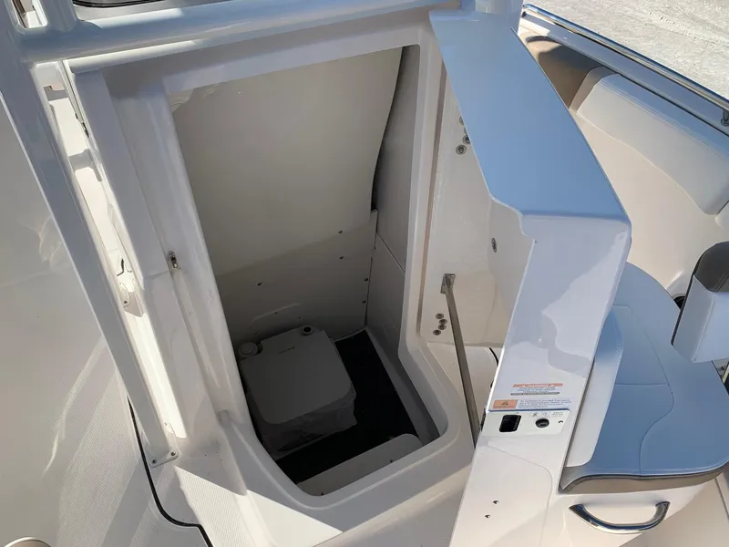 Slide: The Image of 2024 Robalo R222 Center Console boat interior with built-in toilet. - 14
