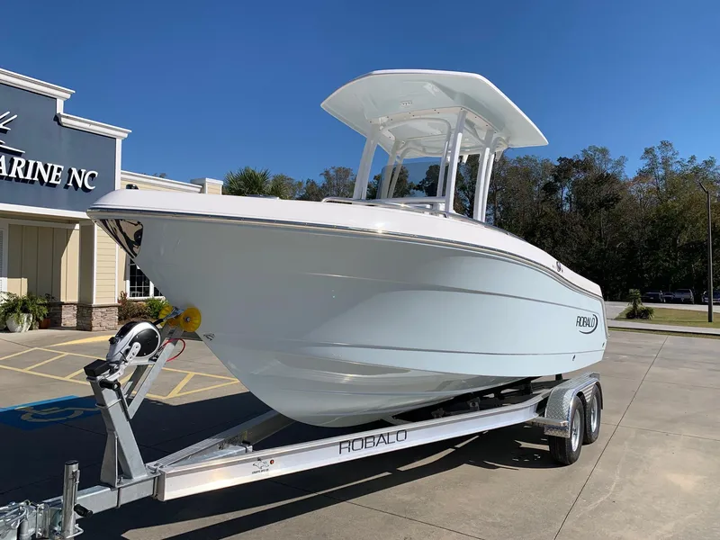 Slide: The Image of 2024 Robalo R222 Center Console boat on a trailer outside a marine dealership. - 3
