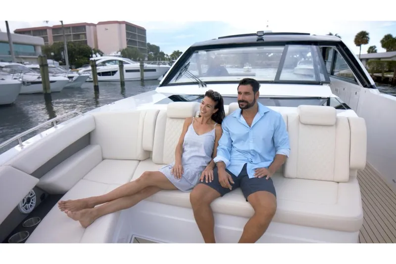 Slide: The Image of Couple relaxing on 2023 Cruisers Yachts 50 GLS luxury boat at marina. - 6
