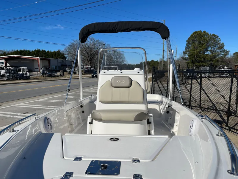 Slide: The Image of 2023 Key West 1720 Center Console boat with seating, parked outdoors under clear blue sky. - 7