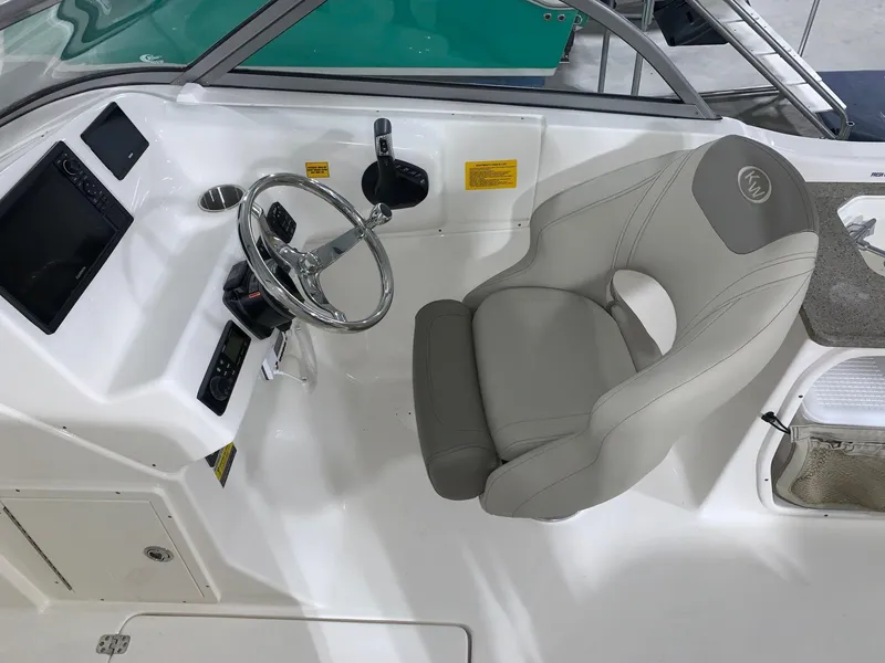 Slide: The Image of 2024 Key West 239 DFS boat cockpit with steering wheel and captain's chair. - 7