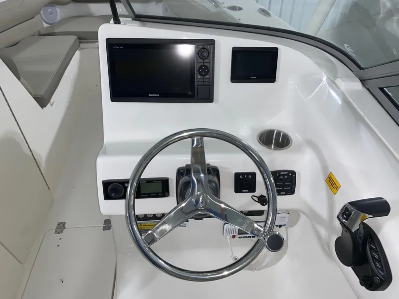 Slide: The Image of 2024 Key West 239 DFS boat dashboard with steering wheel and navigation controls. - 8