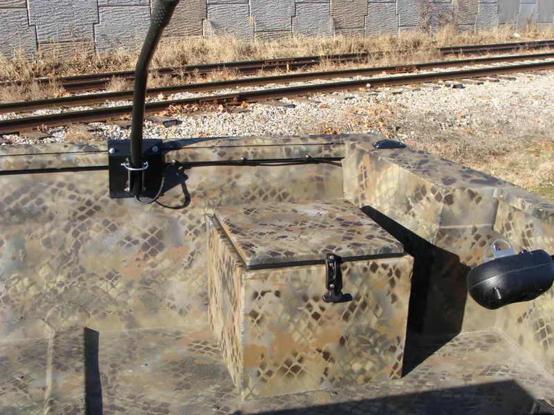 Slide: The Image of 2023 Excel 1754 Pro F4 boat interior with camouflage design near railway tracks. - 16