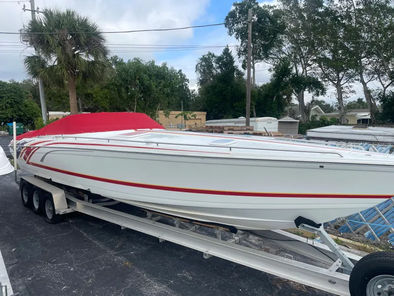 Slide: The Image of 2007 Formula 353 FASTech boat on trailer with red cover, parked outdoors. - 11