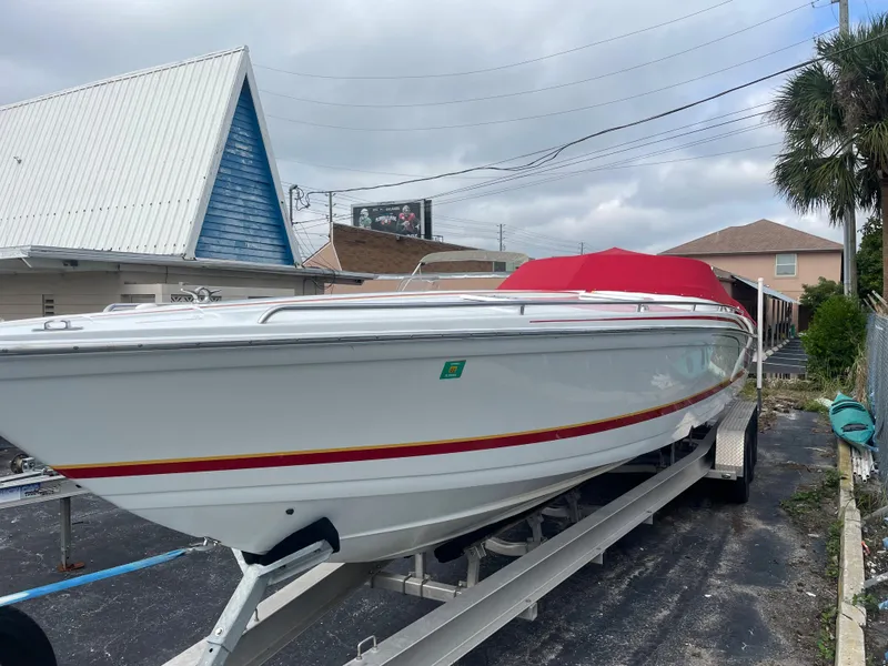 Slide: The Image of 2007 Formula 353 FASTech boat on trailer with red cover, parked outdoors. - 13