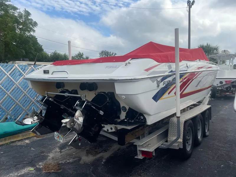 Slide: The Image of 2007 Formula 353 FASTech boat on trailer with red cover, parked outdoors. - 14
