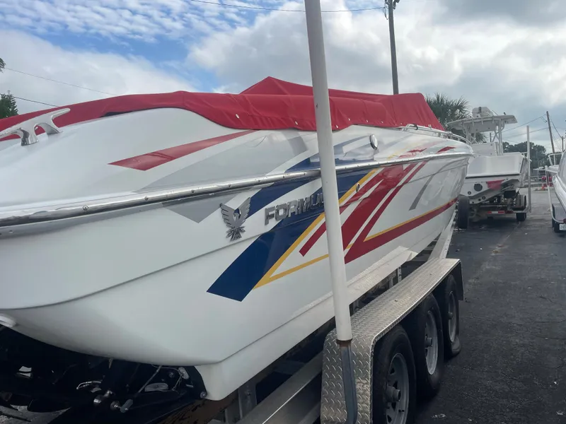 Slide: The Image of 2007 Formula 353 FASTech boat with vibrant graphics on a trailer, covered with a red tarp. - 15