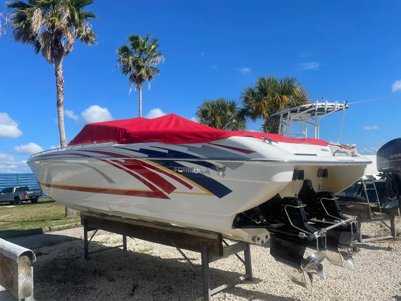 Slide: The Image of 2007 Formula 353 FASTech speedboat with red cover on a stand, palm trees in background. - 17