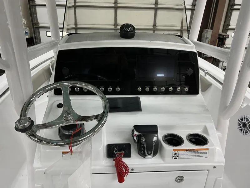 Slide: The Image of 2023 Sportsman 211 Heritage boat dashboard with steering wheel and control panel. - 13