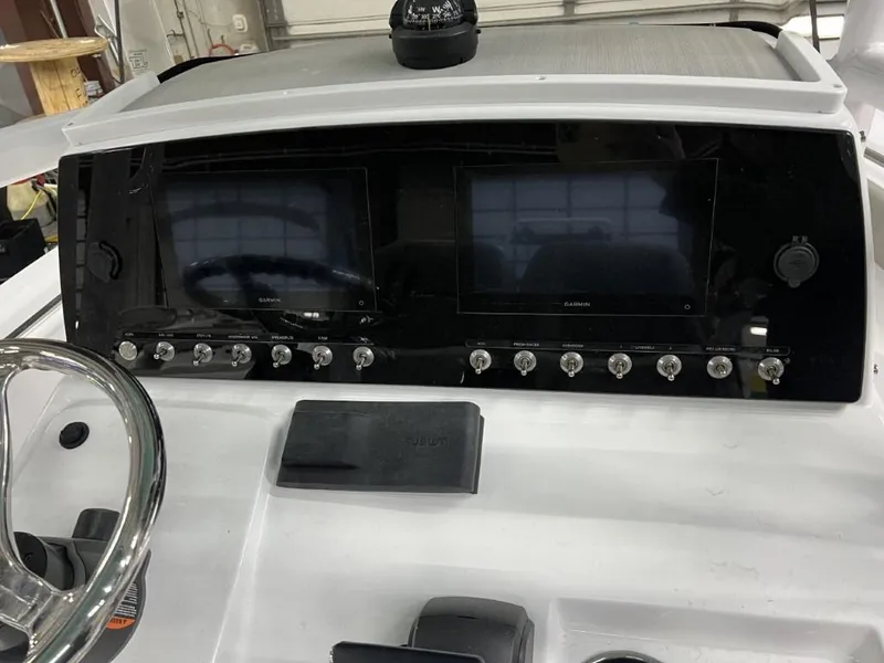 Slide: The Image of 2023 Sportsman 211 Heritage boat dashboard with dual Garmin displays and control switches. - 14