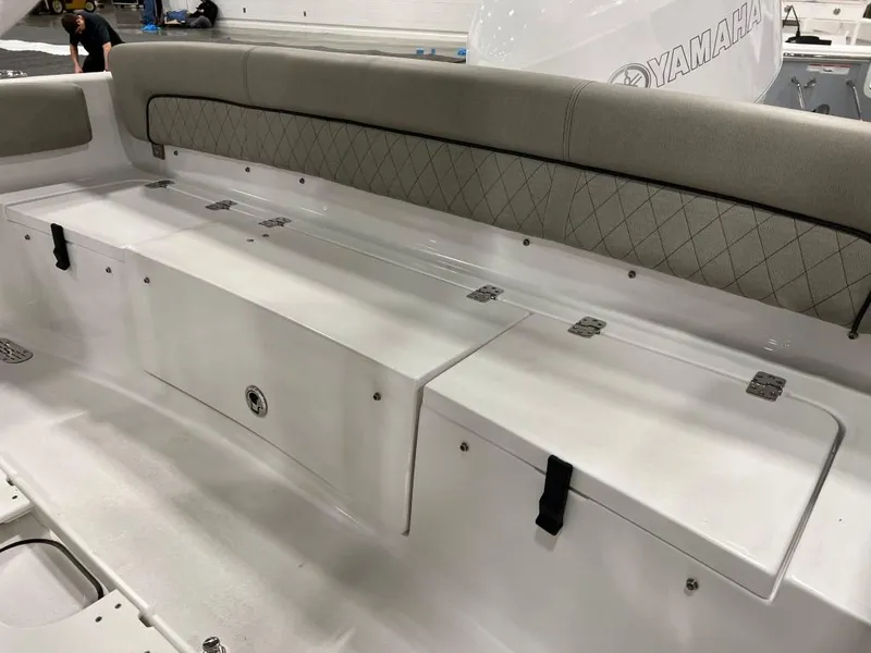 Slide: The Image of 2023 Sportsman 211 Heritage boat interior with cushioned seating and storage compartments. - 21