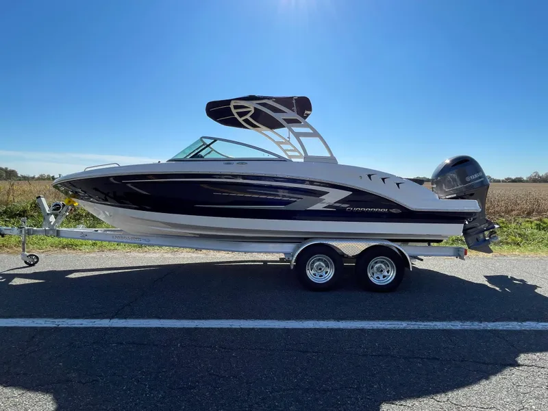 The Image of 2024 Chaparral 23 SSi OB boat on a trailer under a clear blue sky. - 0