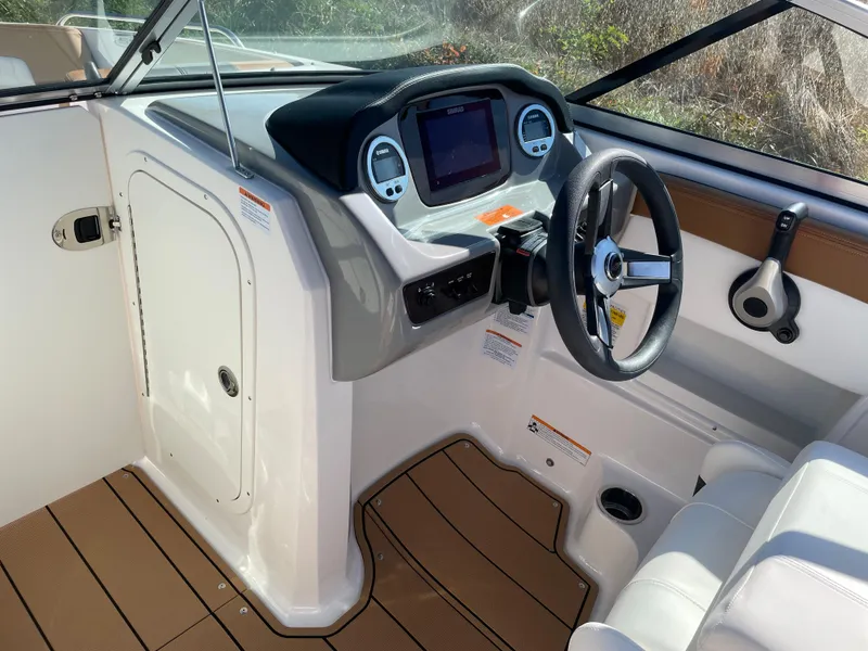 Slide: The Image of 2024 Chaparral 23 SSi OB boat cockpit with steering wheel and control panel. - 19