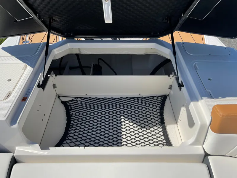 Slide: The Image of Open storage compartment of 2024 Chaparral 23 SSi OB boat with netting. - 34