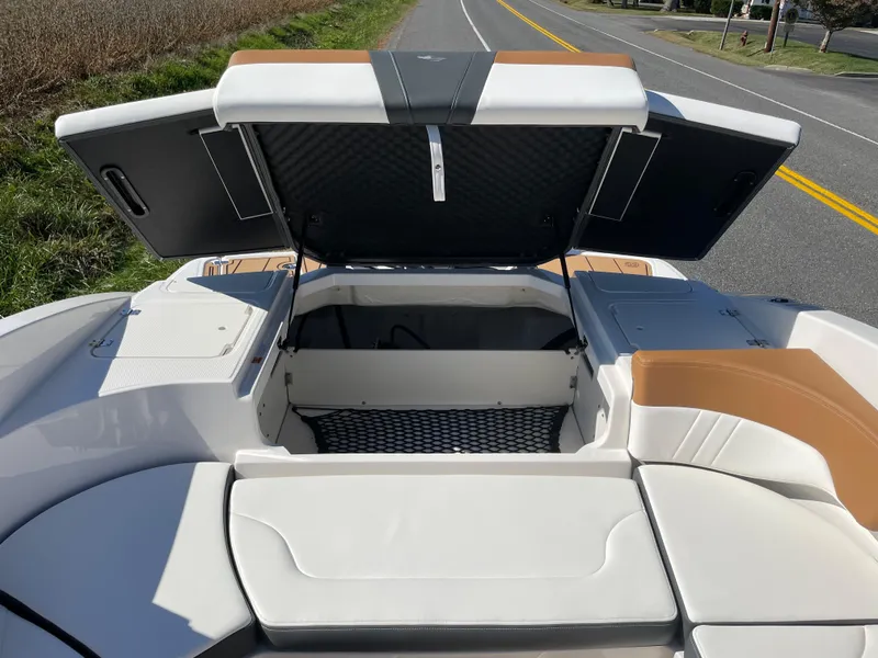 Slide: The Image of 2024 Chaparral 23 SSi OB boat with open storage compartment on a sunny day. - 35