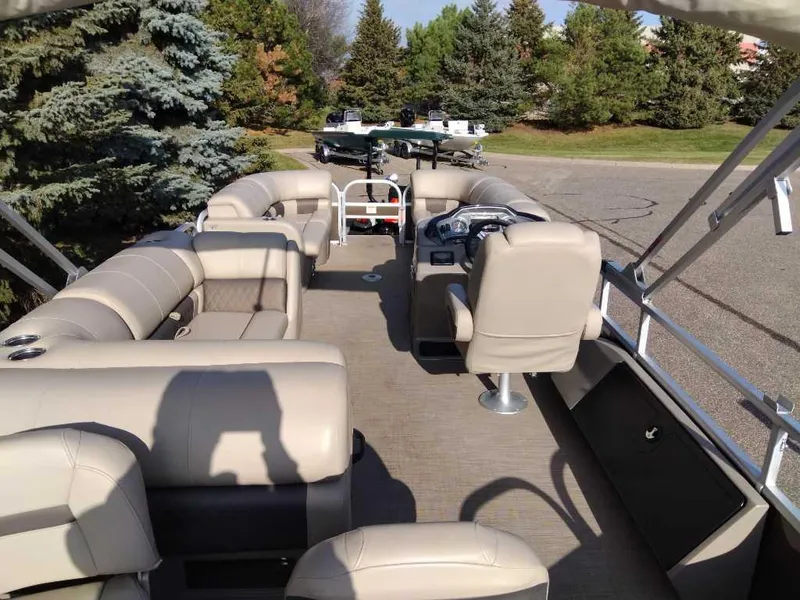 Slide: The Image of 2023 Sun Tracker SportFish 22 DLX pontoon boat with beige seating and spacious deck. - 3