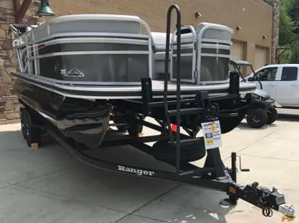 Slide: The Image of 2023 Ranger Reata 220C pontoon boat on a trailer in a driveway. - 3
