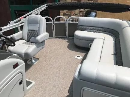 Slide: The Image of 2023 Ranger Reata 220C pontoon boat interior with plush seating and captain's chair. - 9