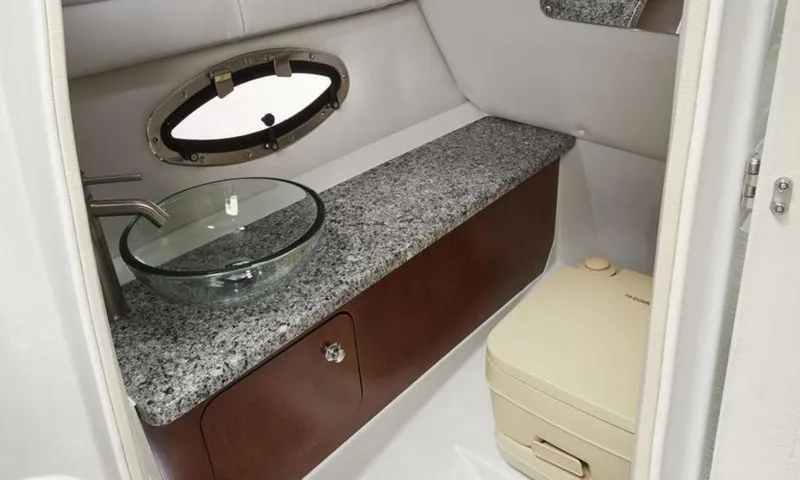 Slide: The Image of 2024 Crownline SS 260 boat bathroom with granite countertop and modern sink. - 7