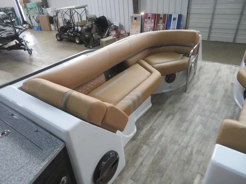Slide: The Image of 2023 Crest Continental 270 NX SLS Twin boat interior with tan seating in a showroom. - 14
