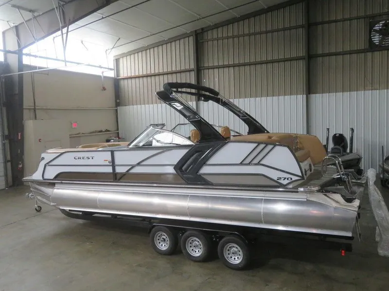 Slide: The Image of 2023 Crest Continental 270 NX SLS Twin pontoon boat in a warehouse. - 3