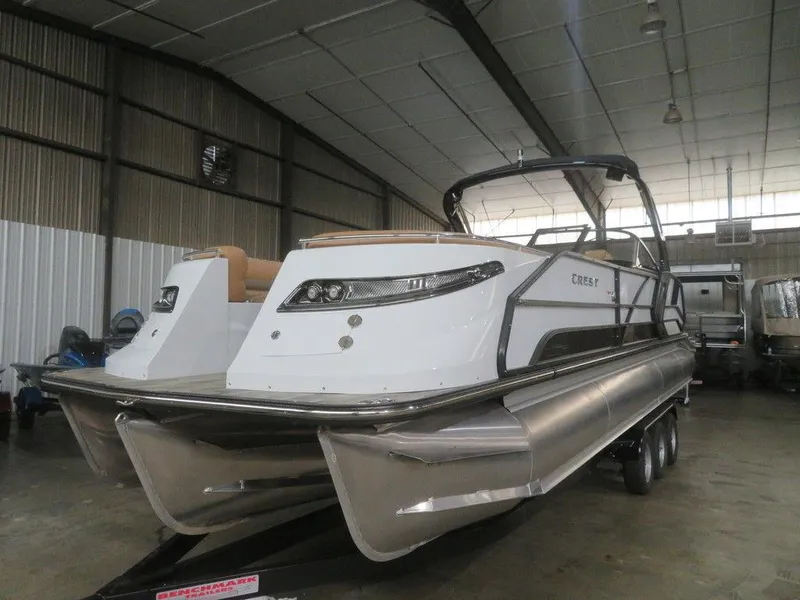 Slide: The Image of 2023 Crest Continental 270 NX SLS Twin pontoon boat in a warehouse. - 4