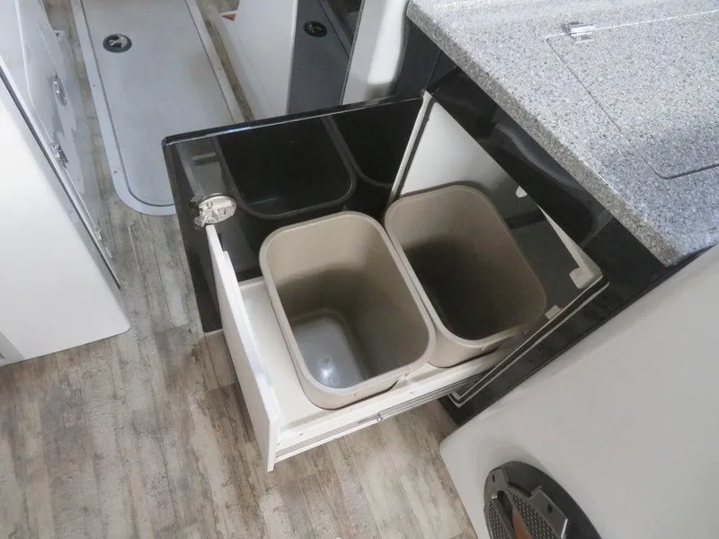 Slide: The Image of 2023 Crest Continental 270 NX SLS Twin kitchen with pull-out trash bins. - 8