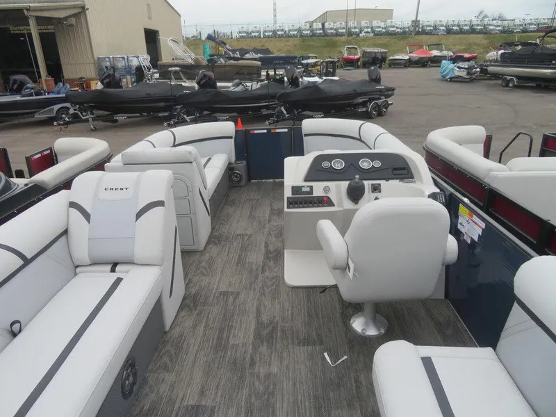 Slide: The Image of 2023 Crest Classic LX 220 L CPT DLX pontoon boat interior with seating and control console. - 16