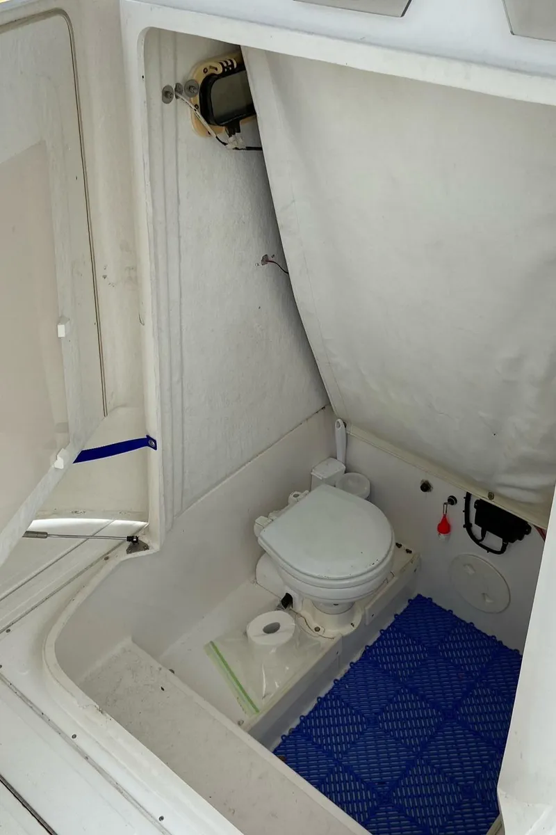 Slide: The Image of 2000 Stamas 290 Tarpon boat interior with toilet and blue mat. - 12