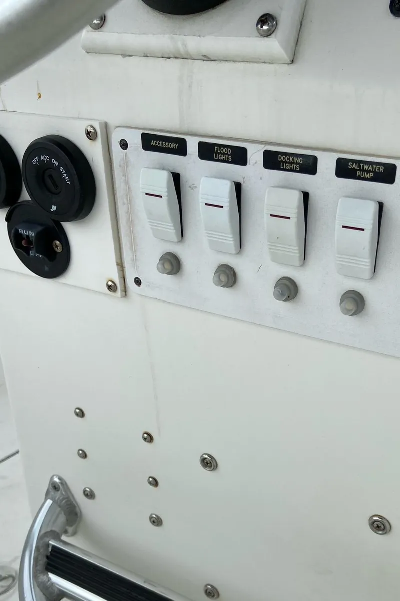 Slide: The Image of Control panel of a 2000 Stamas 290 Tarpon boat with various switches and gauges. - 22
