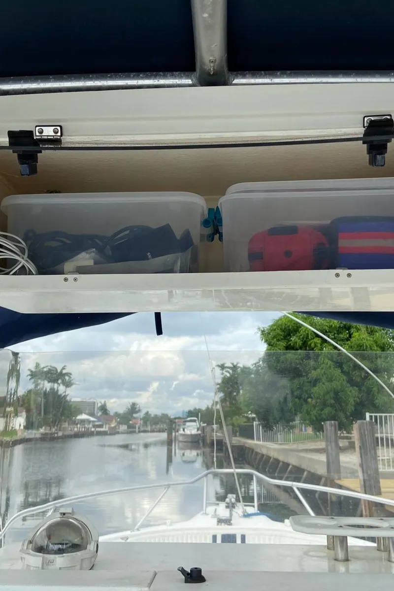Slide: The Image of View from the 2000 Stamas 290 Tarpon boat, showing storage compartments and a scenic waterway. - 23