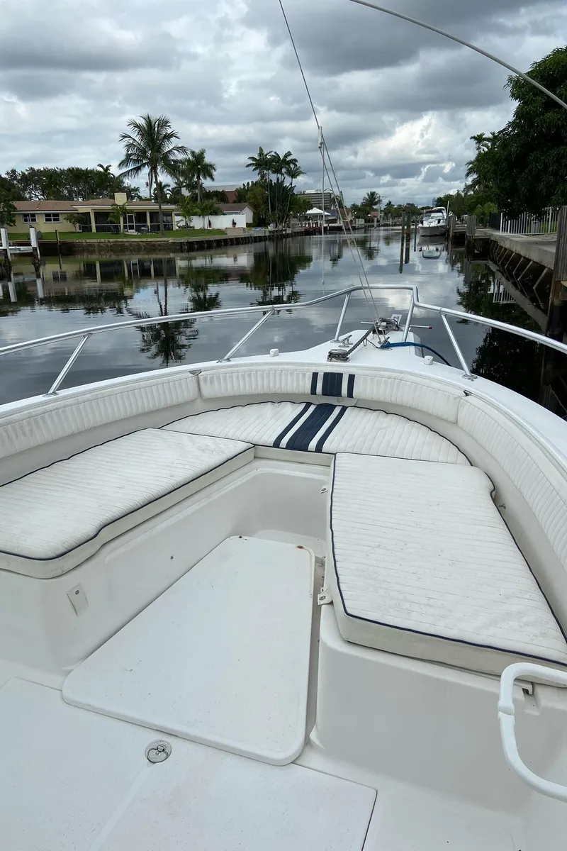 Slide: The Image of 2000 Stamas 290 Tarpon boat on a calm canal with palm trees. - 7