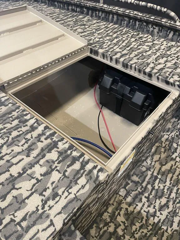 Slide: The Image of 2023 Legend Craft Outlaw 1656 boat with camo pattern and open storage compartment. - 7