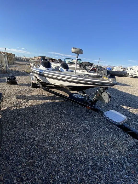 Slide: The Image of 2006 Skeeter Bass Boat on trailer in a gravel lot. - 3