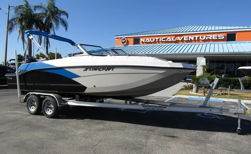 Slide: The Image of 2023 Starcraft SVX 210 OB boat on trailer at Nautical Ventures dealership. - 1