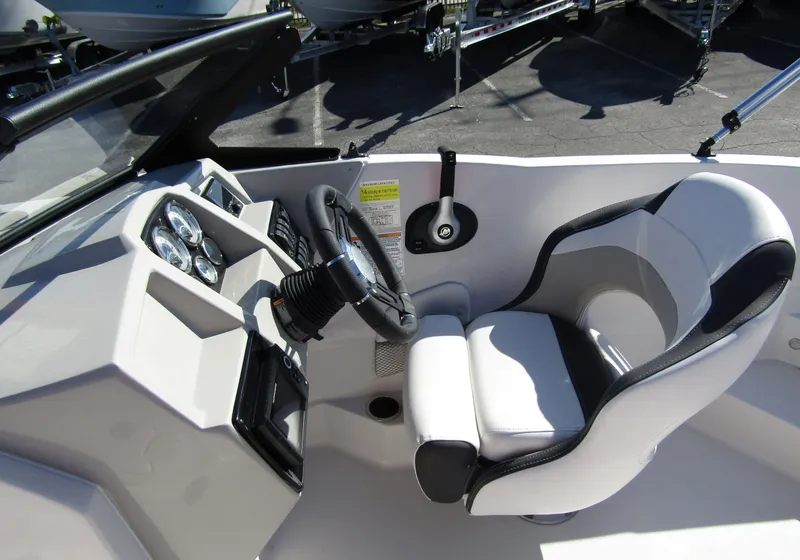 Slide: The Image of 2023 Starcraft SVX 210 OB boat cockpit with steering wheel and captain's chair. - 19