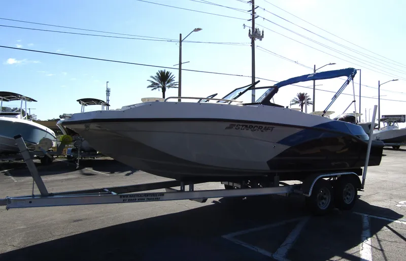 Slide: The Image of 2023 Starcraft SVX 210 OB boat on a trailer in a parking lot. - 2
