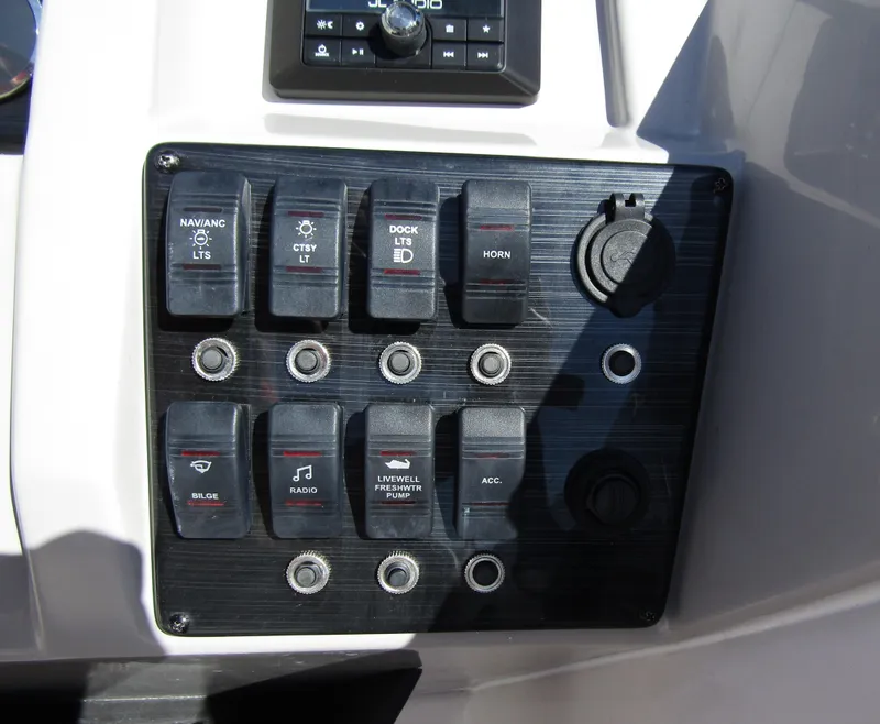 Slide: The Image of Control panel of 2023 Starcraft SVX 210 OB boat with various switches and buttons. - 24
