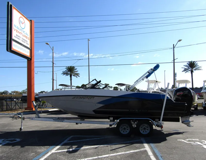 Slide: The Image of 2023 Starcraft SVX 210 OB boat on a trailer at a dealership. - 3