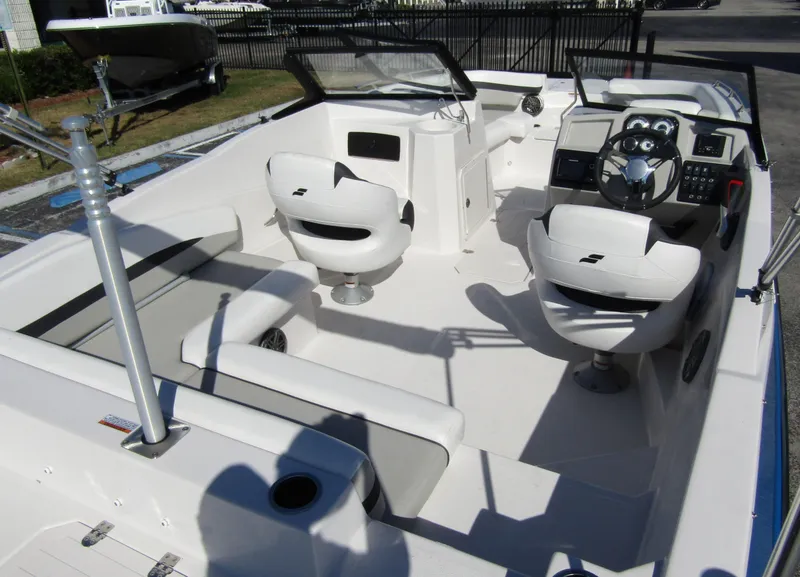 Slide: The Image of 2023 Starcraft SVX 210 OB boat interior with white seating and modern dashboard. - 31