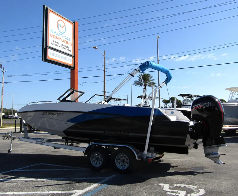 Slide: The Image of 2023 Starcraft SVX 210 OB boat on trailer at Nautical Ventures dealership. - 4