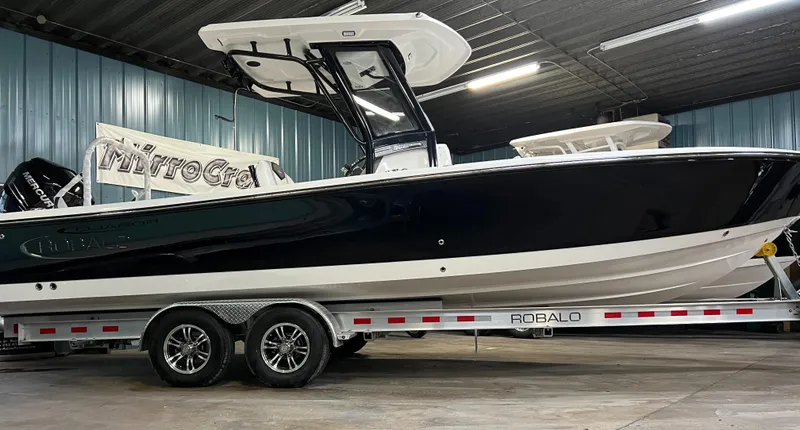 Slide: The Image of 2023 Robalo 266 Cayman boat on a trailer in a showroom. - 2