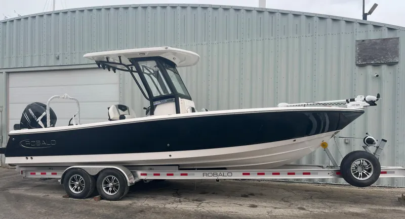 Slide: The Image of 2023 Robalo 266 Cayman boat on a trailer outside a metal building. - 3