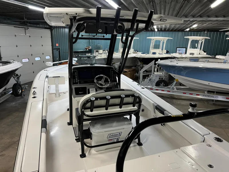 Slide: The Image of 2023 Robalo 266 Cayman boat interior in a showroom, featuring helm and seating. - 8