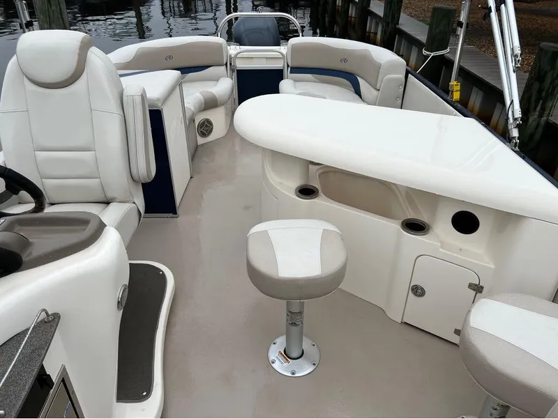 Slide: The Image of 2013 Avalon AMBASSADOR 2785 ENTERTAINER boat interior with white seating and helm. - 12