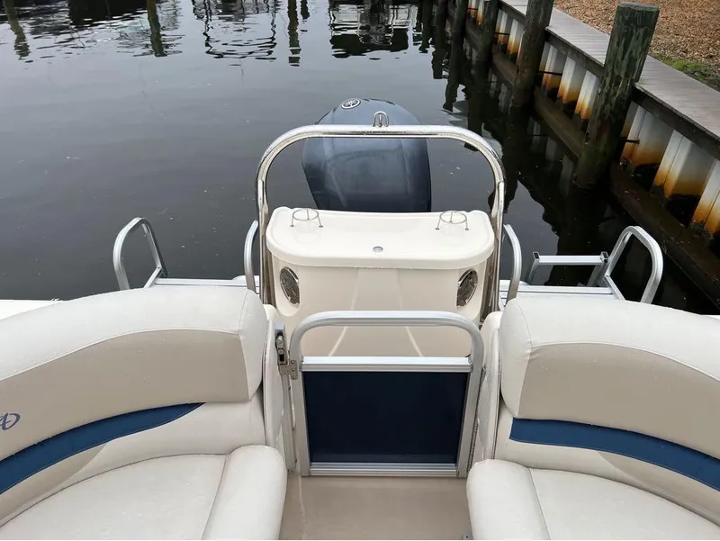 Slide: The Image of 2013 Avalon AMBASSADOR 2785 ENTERTAINER boat interior with seating and motor. - 16