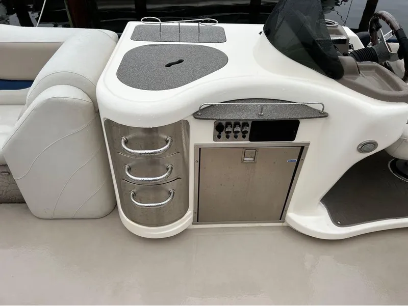 Slide: The Image of 2013 Avalon AMBASSADOR 2785 ENTERTAINER boat interior with control panel and storage drawers. - 4