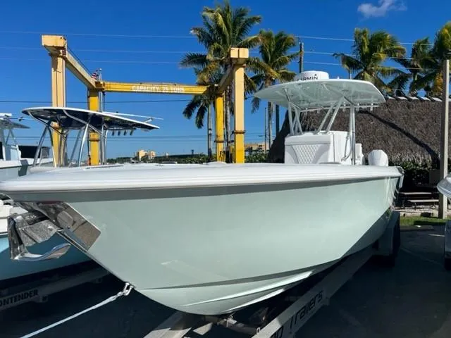 Slide: The Image of 2025 Contender 35 ST boat on trailer, surrounded by palm trees and blue sky. - 2