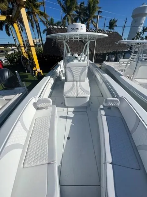 Slide: The Image of 2025 Contender 35 ST boat with white seating and Garmin equipment, docked under clear skies. - 21