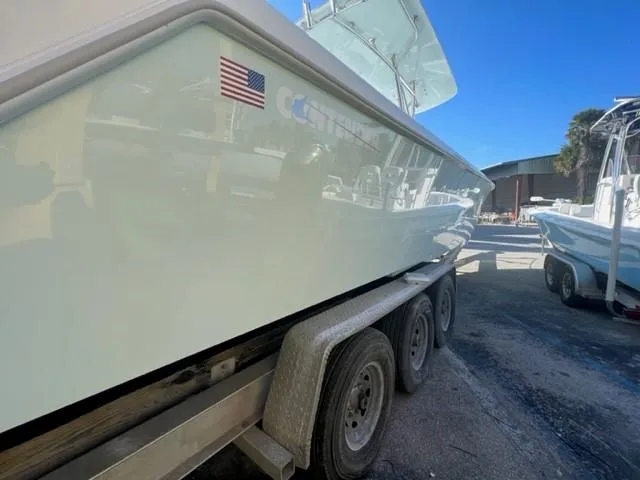 Slide: The Image of 2025 Contender 35 ST boat on trailer, side view with American flag decal. - 22